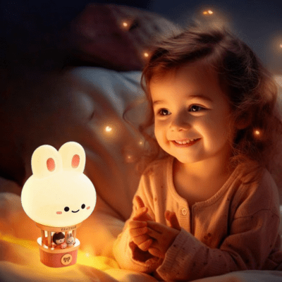 petite fille émerveillée devant sa lampe veilleuse montgolfière