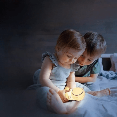 tendre complicité de 2 enfants devant la veilleuse astronaute tomy