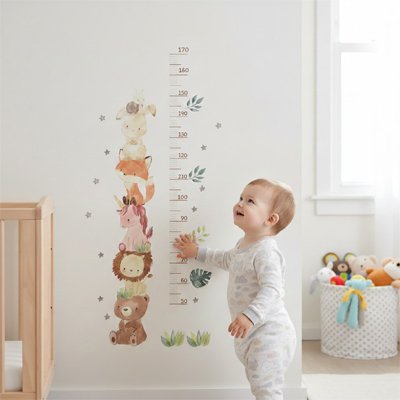bébé devant sa Toise collée sur le mur 