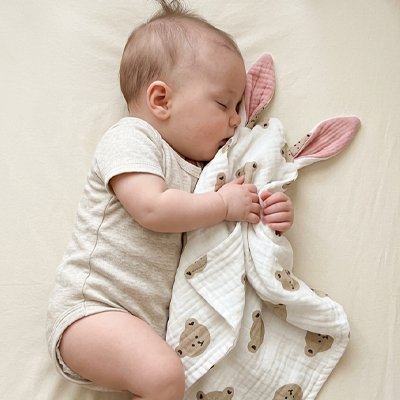 Bébé dort avec Doudou contre son visage