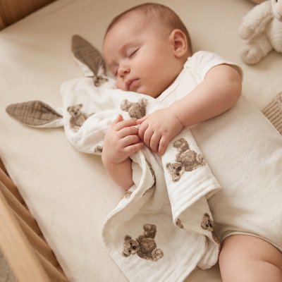 bébé dort avec son Doudou serré contre sa poitrine