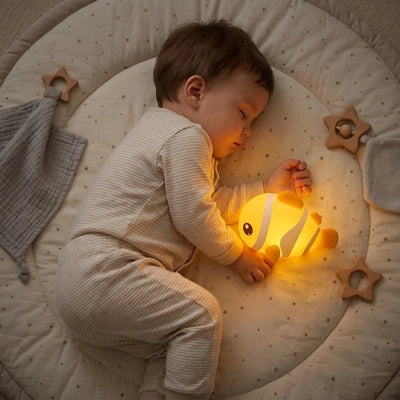 bébé dort avec veilleuse bébé poisson dans ses mains